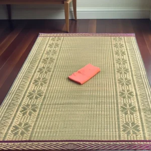 Extra large handwoven reed grass floor mat with traditional border placed on wooden floor for indoor home décor and sleeping
